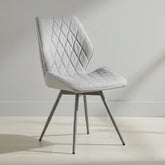 Gray quilted chair on a light wooden floor with a neutral background