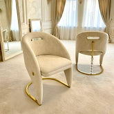 Luxurious interior with beige chairs, large mirror, and elegant decor.