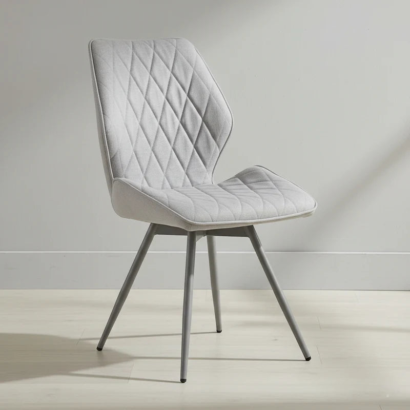 Gray quilted chair on a light wooden floor with a neutral background