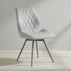 Gray quilted chair on a light wooden floor with a neutral background